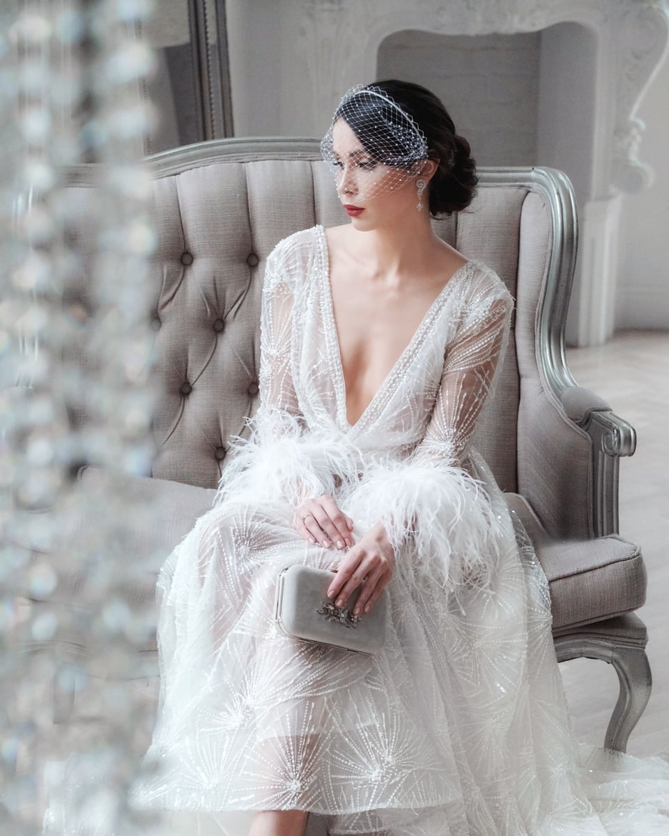 Illustrative photograph of a bride in an ivory gown seated on an ornate armchair.
